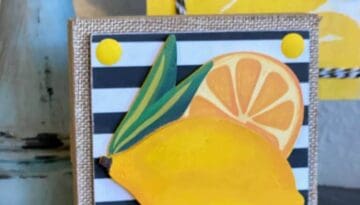 Lemon and lemon slice wooden cutout on a small wooden block with a black and white striped background on top of burlap. Easy summer diy tiered tray decor.