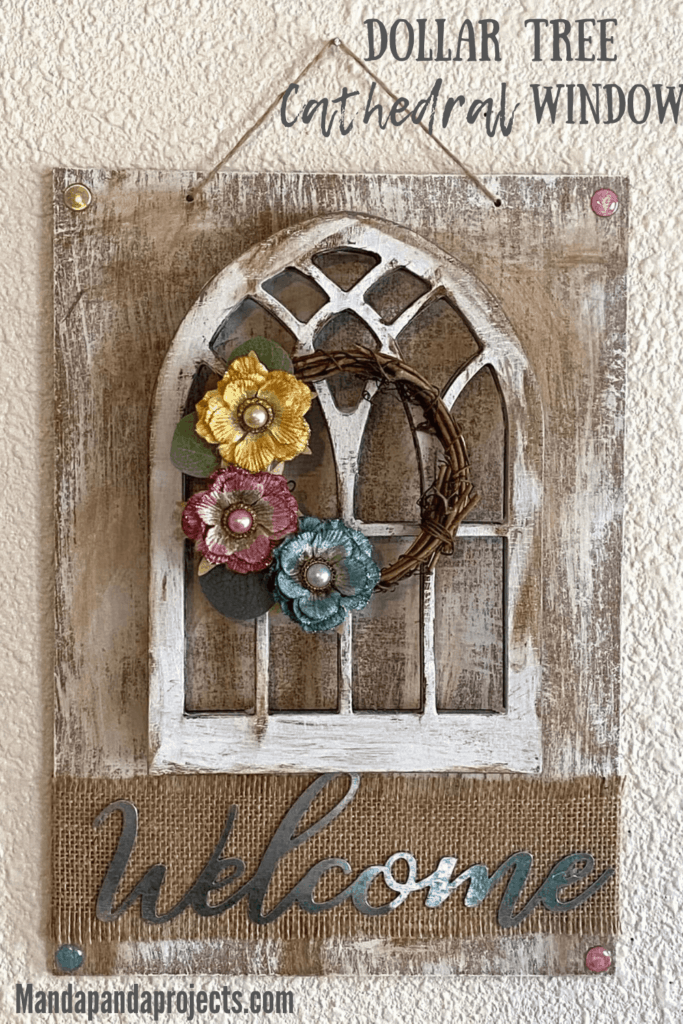 DIY Dollar Tree Cathedral window decor craft with a mini grapevine wreath and scrapbook embellishment flowers and a galvanized metal Welcome sign.