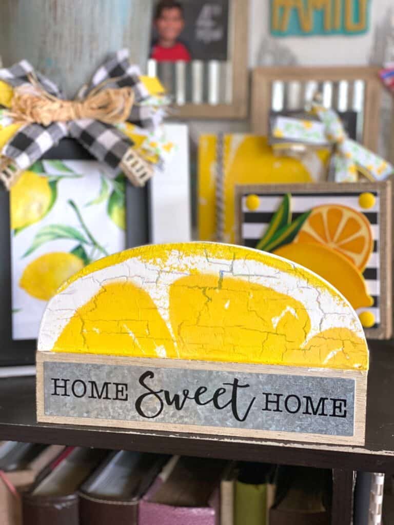 Dollar tree Home sweet home shelf sitter makeover to decorate a lemon themed tiered tray with a lemon napkin mod podged on top and the crackle paint finish showing through for a distressed old look.