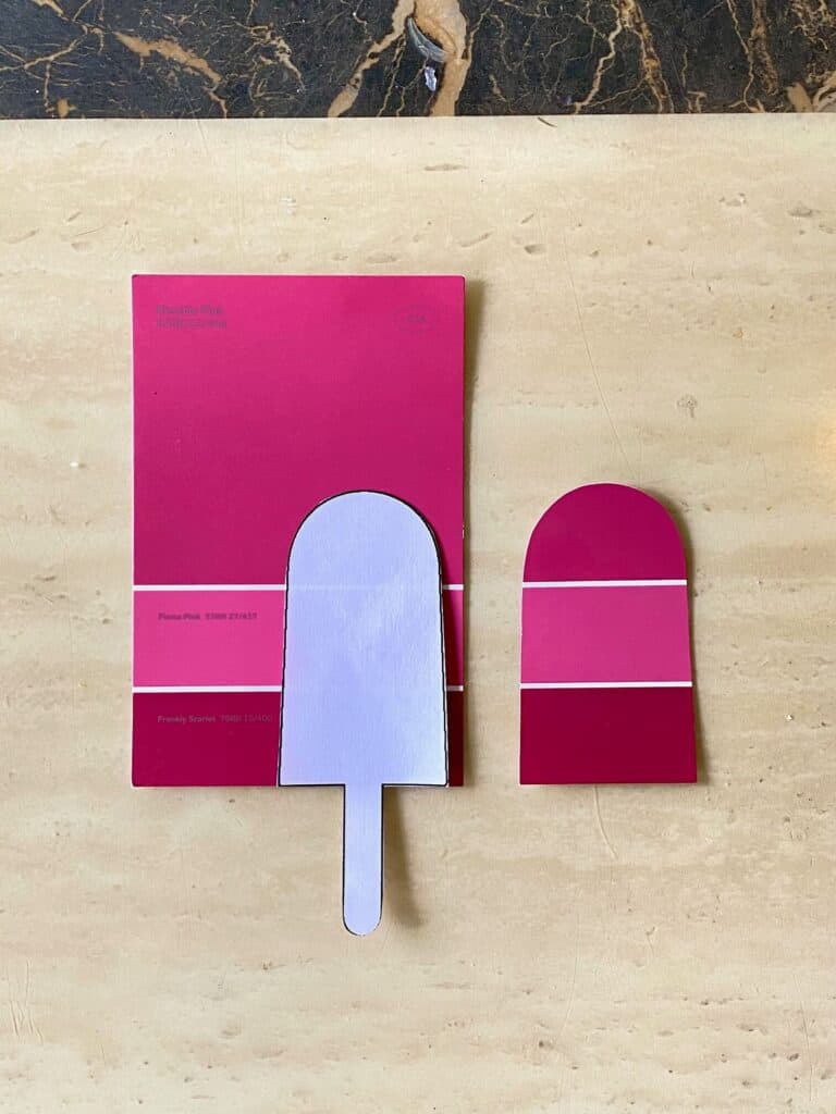 A pinkish red paint chip card with a paper popsicle shaped template to cut it out with.