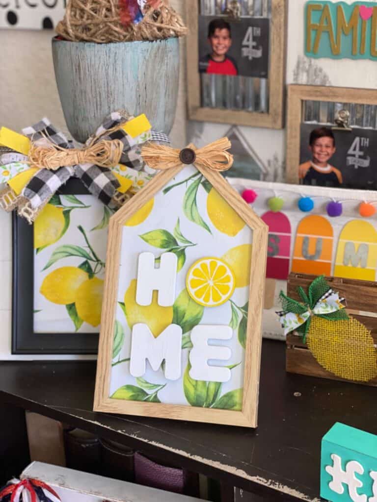House shaped picture frame with a lemon background and the word "Home" with the O being a lemon slice.