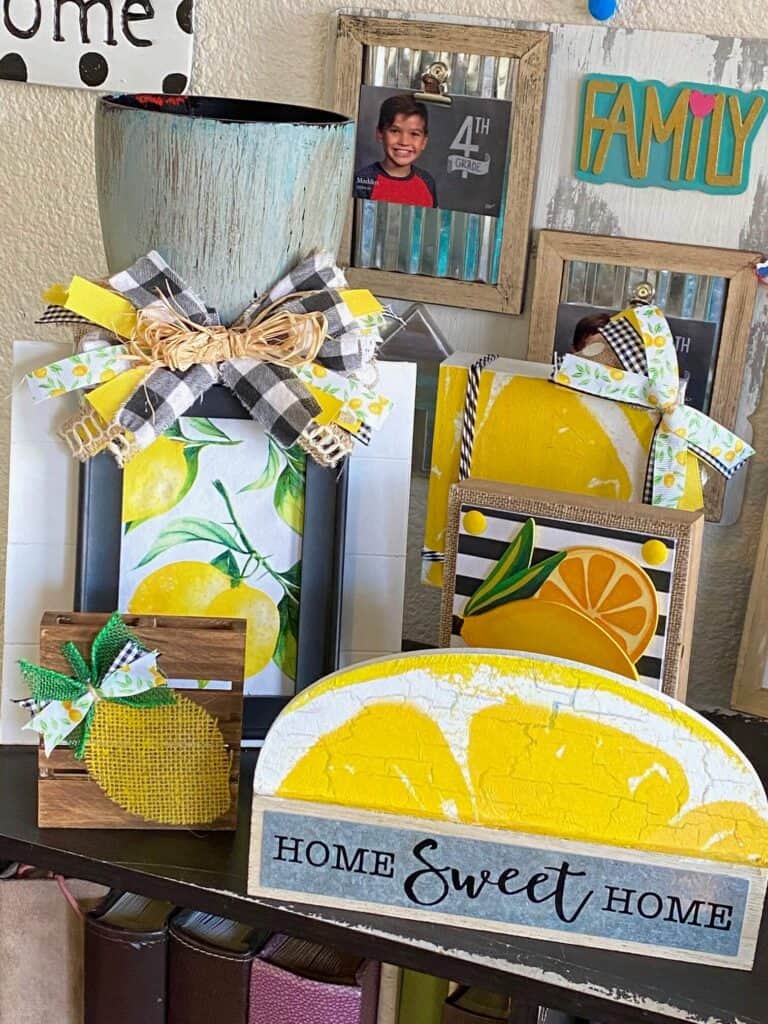 A bookshelf full of various summer lemon themed DIY crafts and decor. All dollar tree made crafts with lots of bright yellow.
