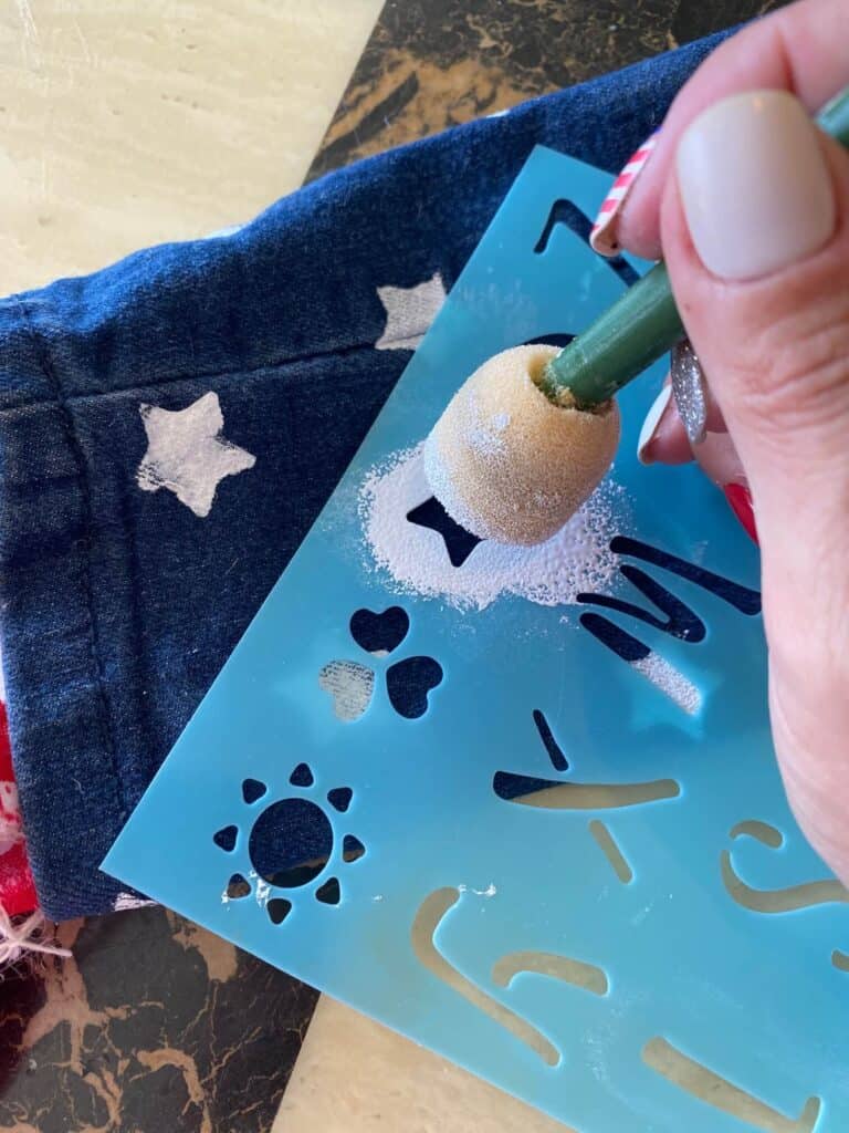 Using a stencil and white paint, make stars all over the blue jeans to make the top of the American Flag.