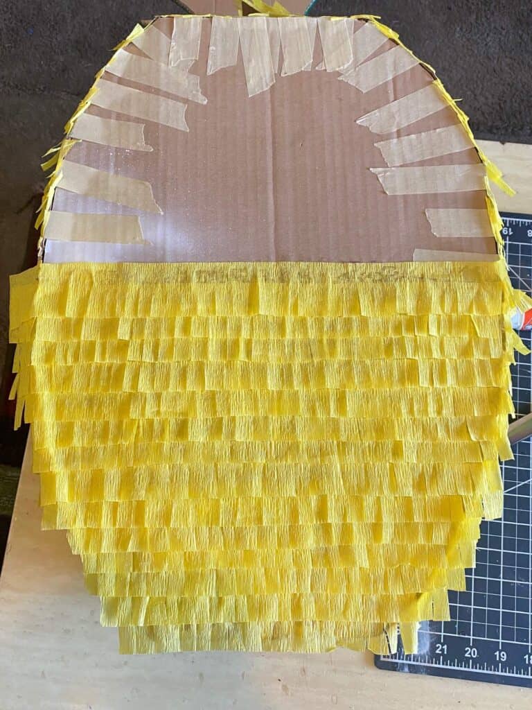 Trim the extra yellow crepe paper overhang from around the Pineapple outline.