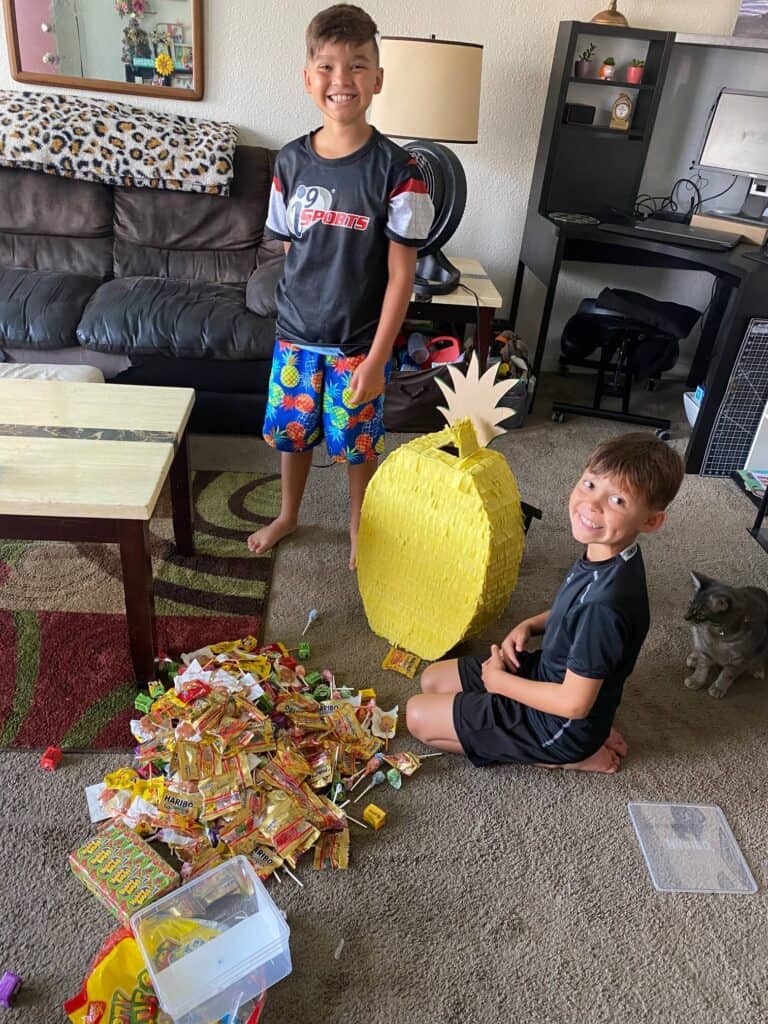 My Twins excitedly filling up the pineapple piñata with tons of candy and huge smiles on their faces.
