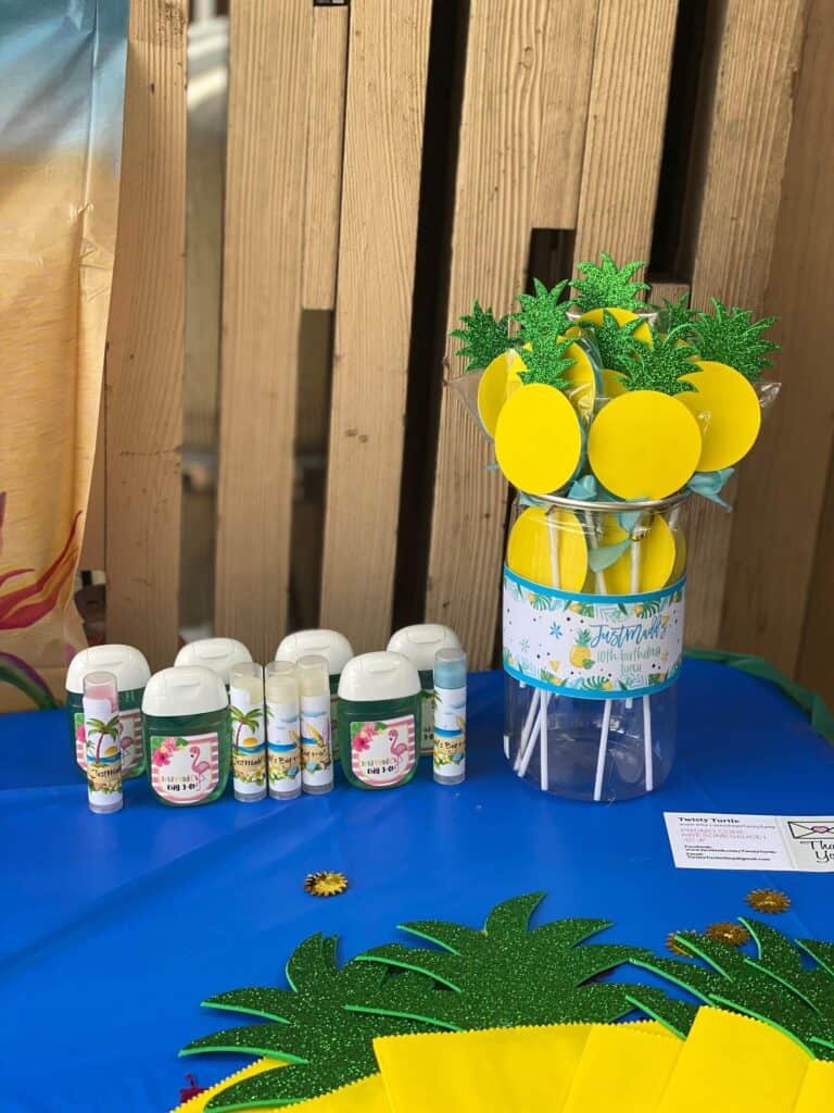 DIY Pineapple lollipop party favors for a Hawaiian Luau party with mini sanitizer bottles and Chapstick party favors.