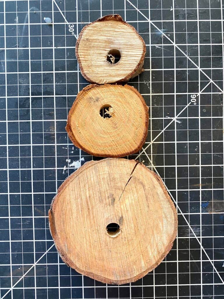 3 natural wooden rounds glued on top of each other to form the wooden snowman body.