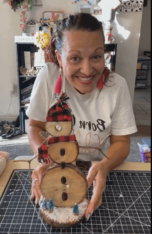 Amanda smiling and holding the completed Rustic Wooden snowman. 