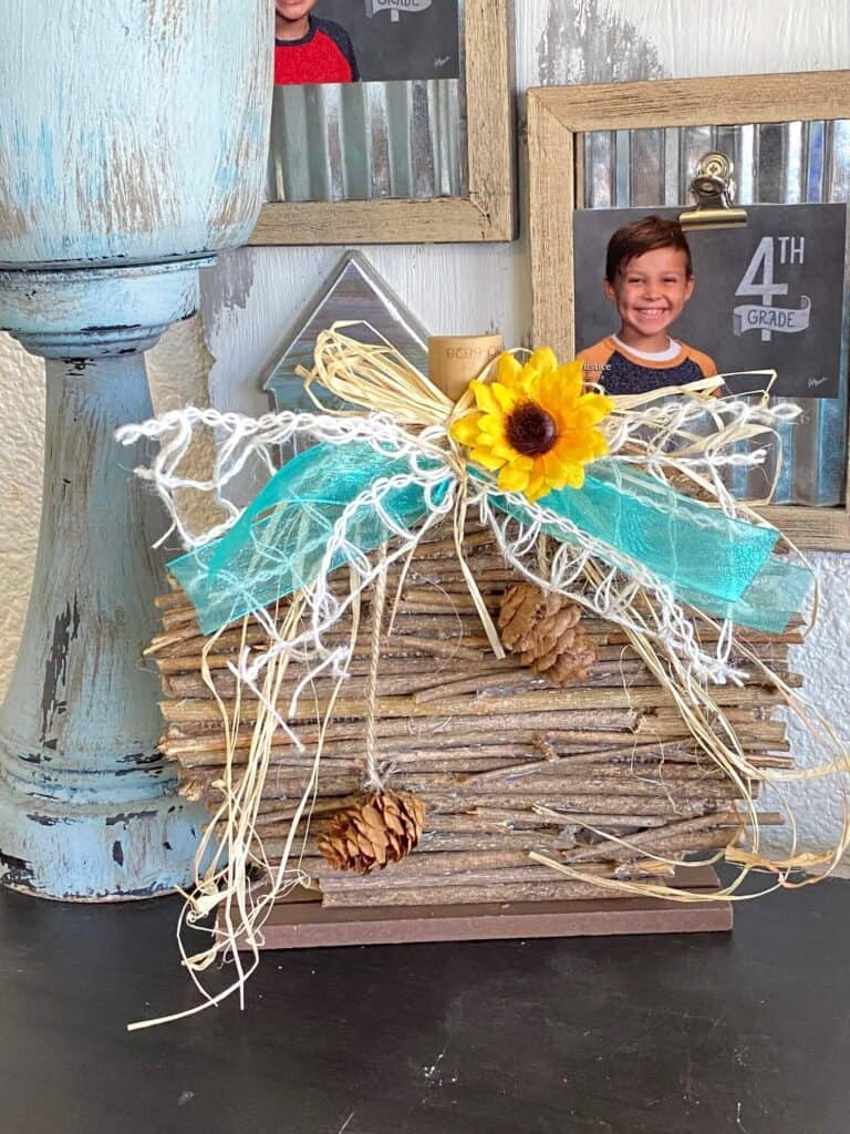 DIY Dollar Tree Rustic Country Wooden Stick Pumpkin Makeover with teal lattice bow and sunflower and pine cone embellishment for diy crafts and decor.