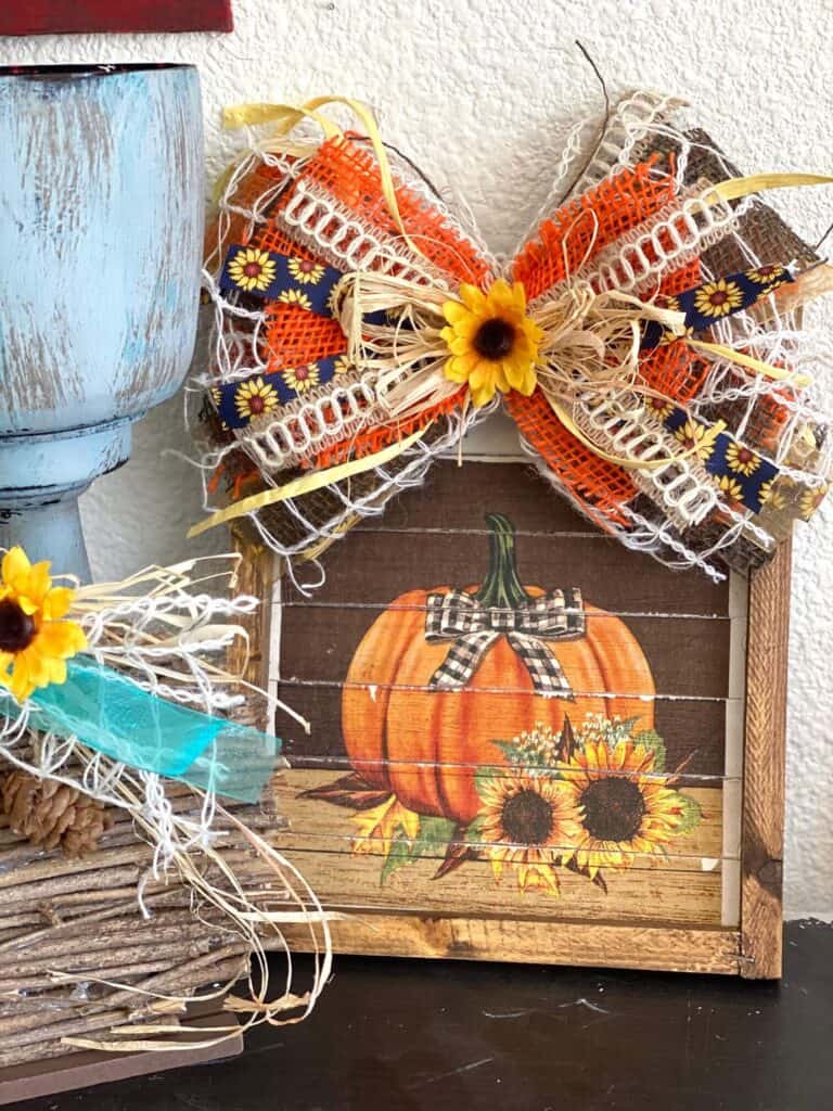 DIY Fall Pumpkin and Sunflower napkin  Reverse Canvas with Messy Bow fall craft and decor next to a pumpkin made from sticks.