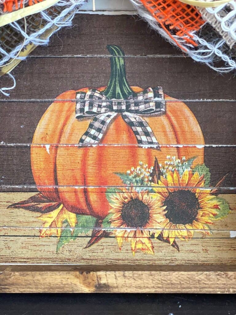 Close-up of the sunflower pumpkin napkin glued together like planks so you can see where it is distressed in between each paint/stick/plank.