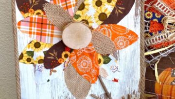 DIY Fall fabric and burlap sunflower with chippy paint background and jute rope rim and a wooden cutout of the word "gather". Autumn decor.