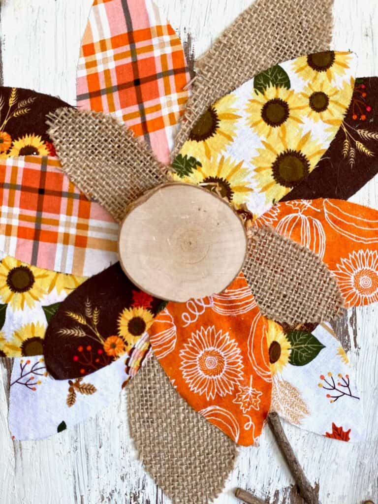 Close up of the center of the fabric and burlap sunflower with a wooden round center.