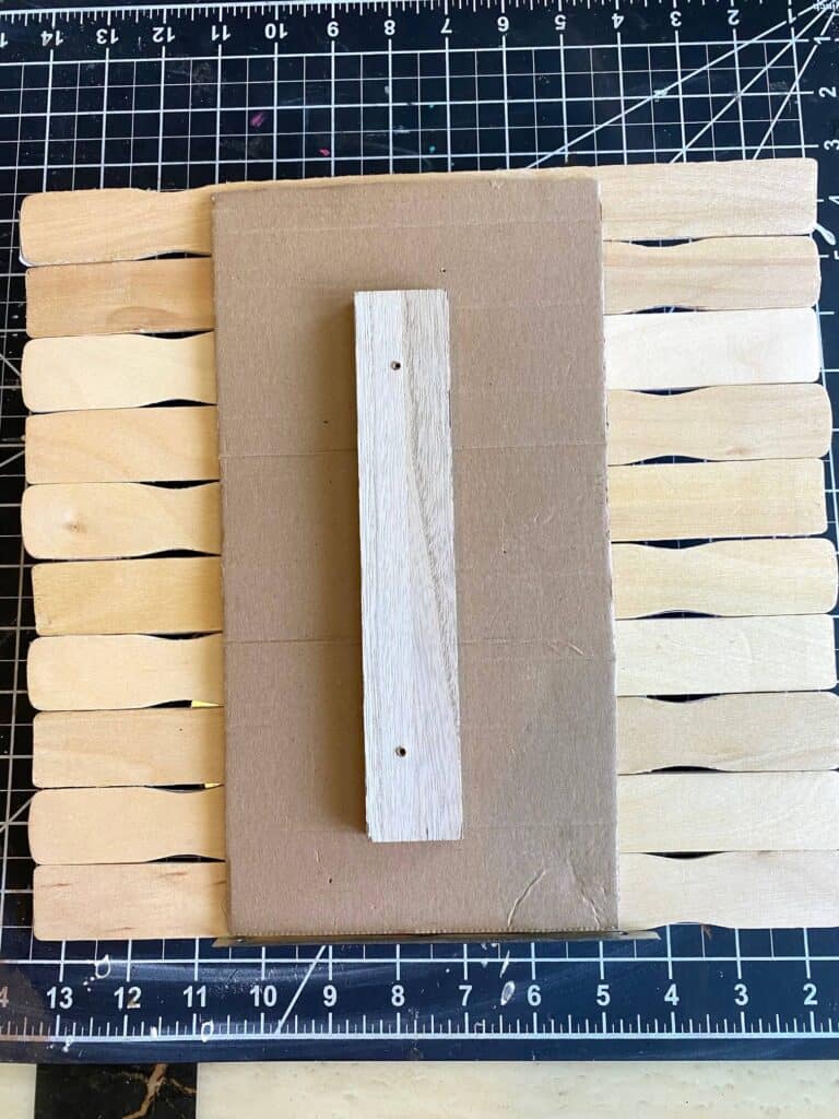 Back of the project showing the paint sticks glued to the cardboard backing with a 