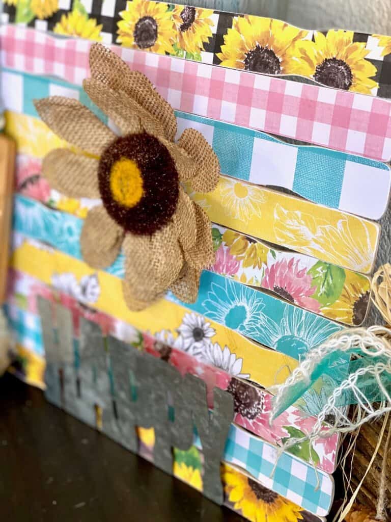 A close up side view of the mod podged scrapbook paper paint sticks and the burlap sunflower.