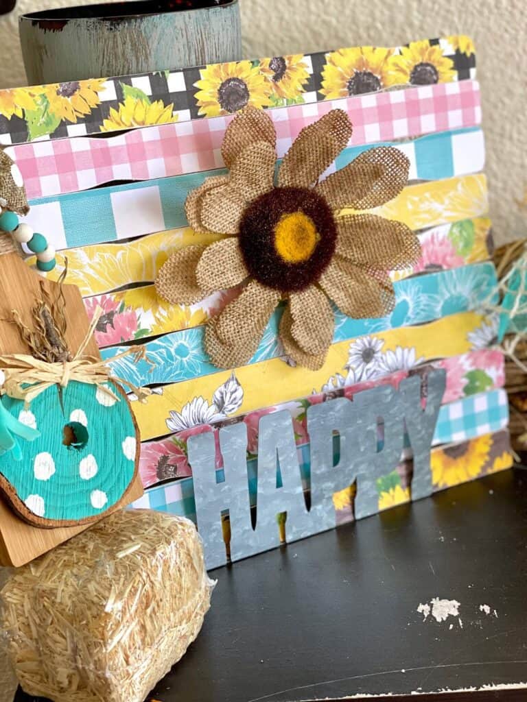 "happy" burlap Sunflower made with Hobby Lobby pink, teal, and yellow Sunflower scrapbook paper and a galvanized metal word "happy" for beautiful crafty decor that works for Spring, Summer, or even Fall. 