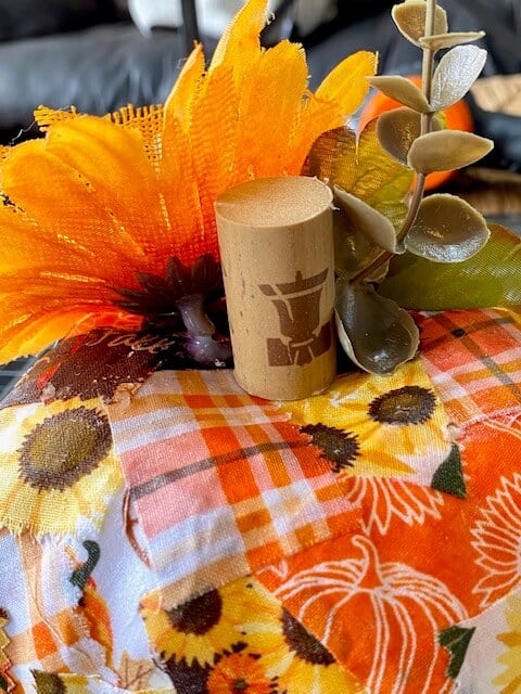 Close up of the wine cork stem with the yellow and burlap sunflower and greenery.