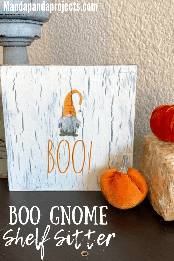 Rae Dunn Boo Gnome napkin Halloween shelf sitter with napkin decoupage and crackle paint method combined, next to a little pumpkin and a hay bale.