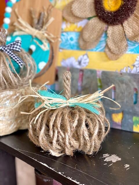 Easy DIY Rustic Twine Pumpkin with a teal and raffia bow and Jute rope stem for fall crafts and decor for a tiered tray.