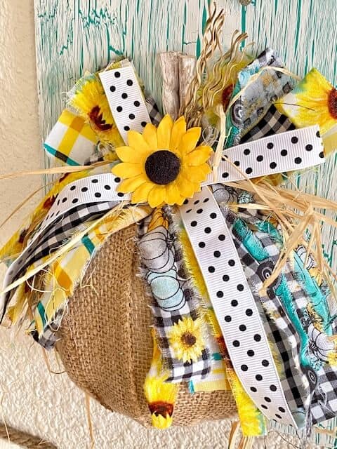Scrappy messy bow on top pf the burlap pumpkin with sunflower teal and truck fabric with black and white polks dot ribbon.