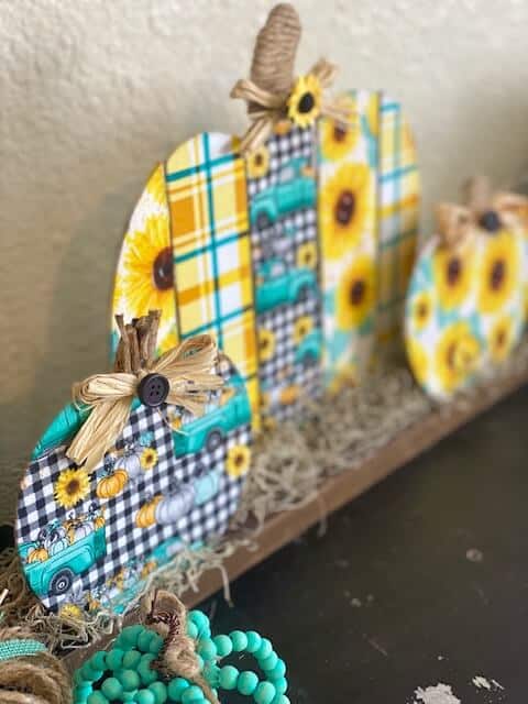 Dollar Tree wooden fabric pumpkin patch DIY with Sunflower truck and teal plaid fabric with spanish moss and twine stems for DIY fall decor.