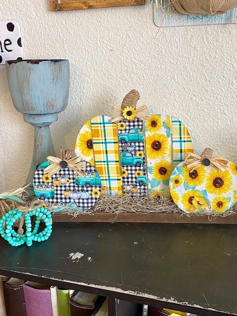 Dollar Tree wooden fabric pumpkin patch DIY with Sunflower truck and teal plaid fabric with spanish moss and twine stems for DIY fall decor.