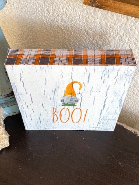 Top of the gnome shelf sitter with orange and grey plaid fabric around the top, bottom, and sides.