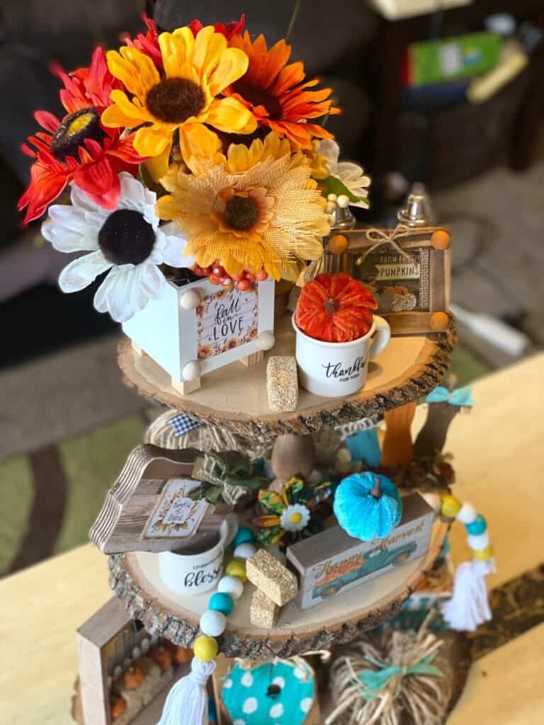Birdseye view of the Handmade rustic fall autumn tiered tray with sunflowers, pumpkins, wood bead garland and pops of Teal.