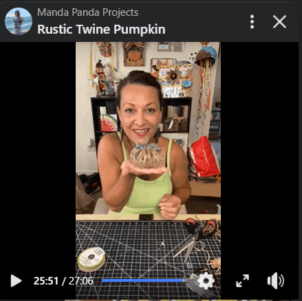 Amanda holding the completed Twine Pumpkin project on a Facebook Live recording.