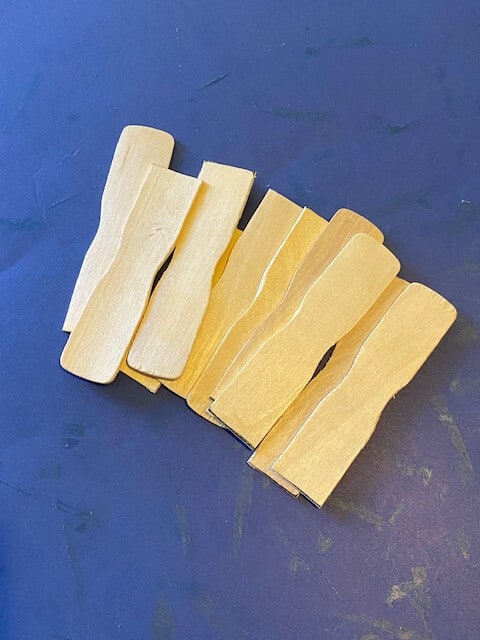 A bunch of pieces of the ends of wooden paint sticks.