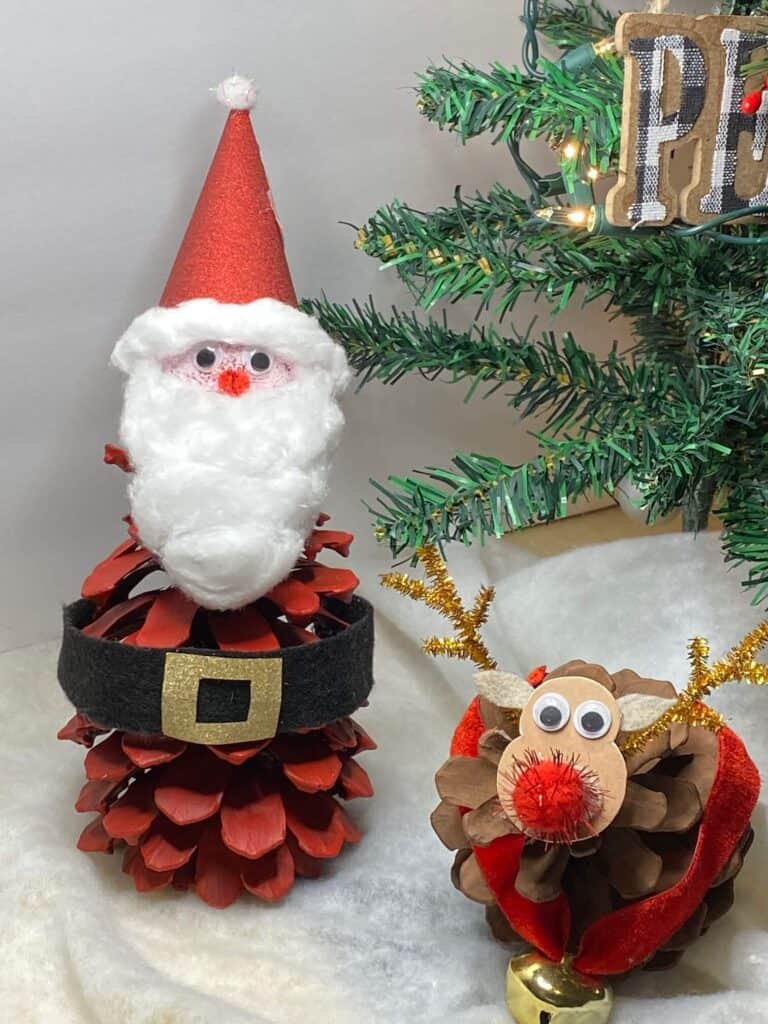 Pine Cone Santa Claus Kids Christmas Craft made with nature supplies  next to rudolph the red-nosed reindeer.