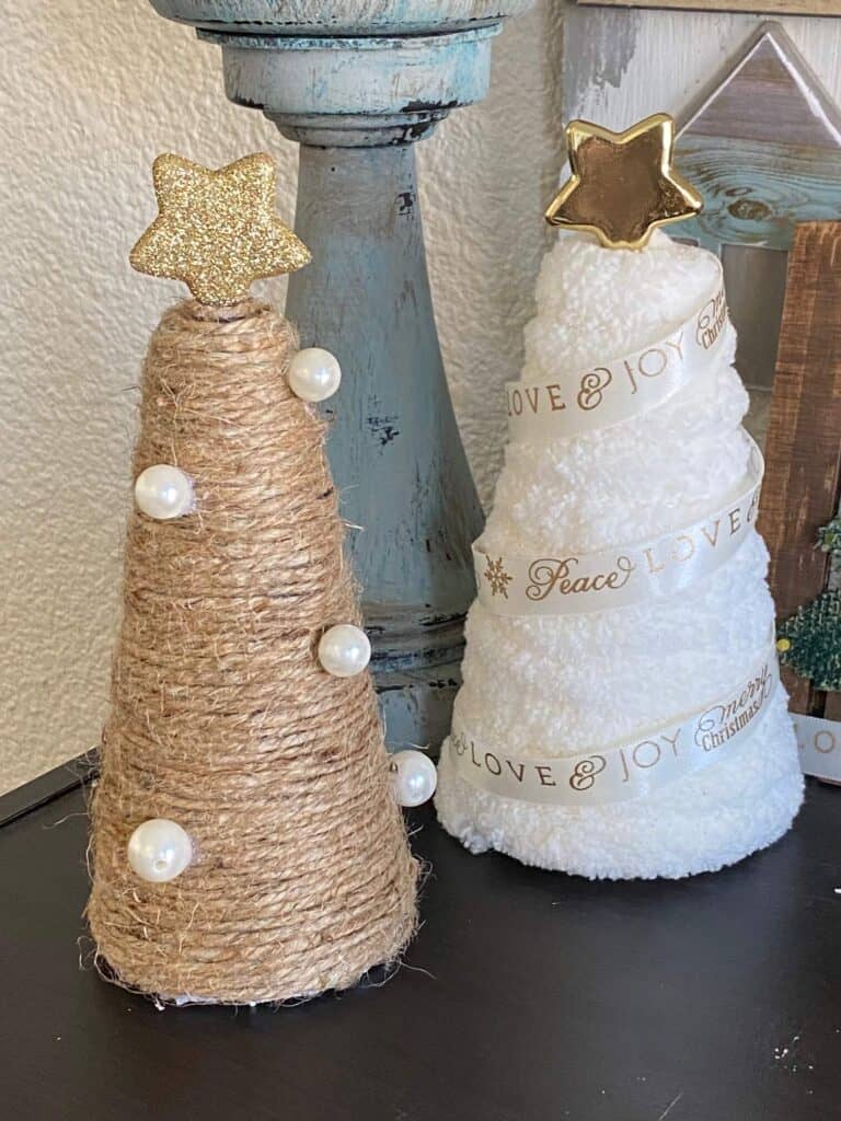 Rustic Twine and white chunky yarn wrapped foam cone Christmas trees made from Dollar Tree supplies with pearls and gold stars on top. DIY Christmas decor.