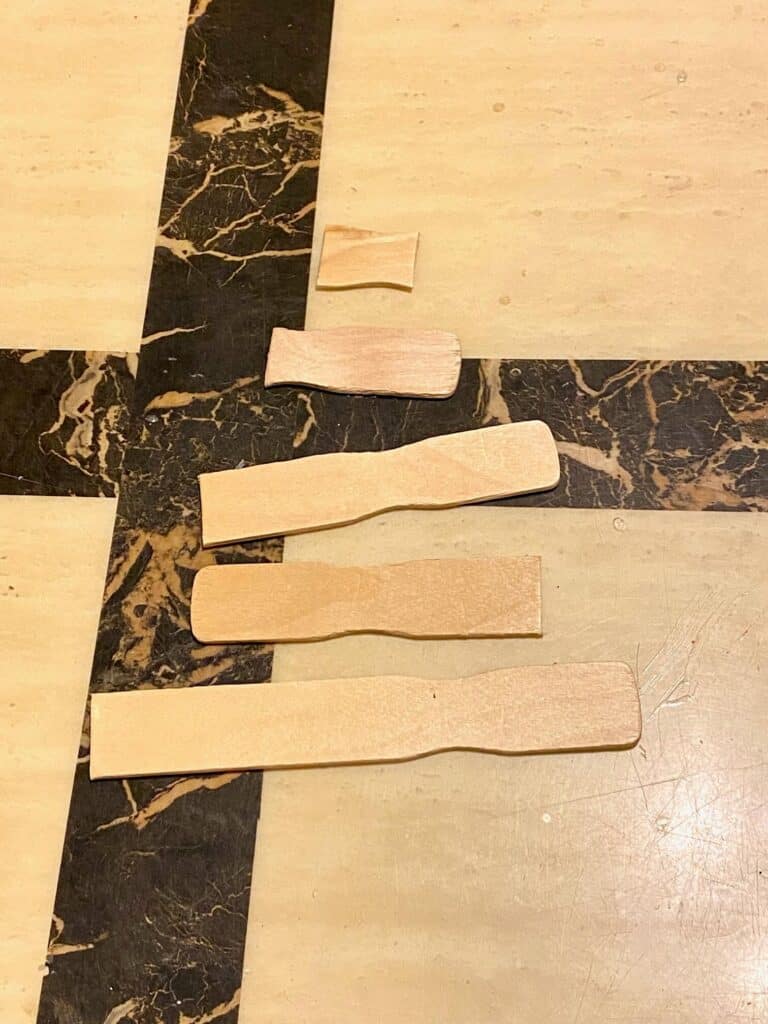 Paint sticks that are cut in various lengths to make the shape of the Christmas Tree.