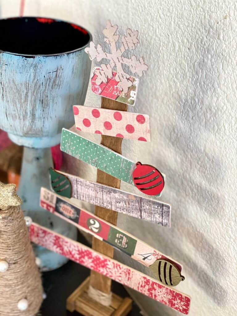 looking down on the Paint stick Christmas tree with vintage scrapbook paper and wooden ornament embellishments. Handmade vintage Christmas decorations.