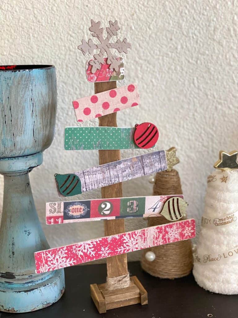 Paint stick Christmas tree with vintage scrapbook paper and wooden ornament embellishments. Handmade vintage Christmas decorations.