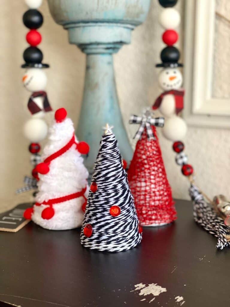 Mini Foam Cone Christmas Trees easy DIY Christmas decor for a red, black, and white theme decorations. With a wood bead garland in the background.