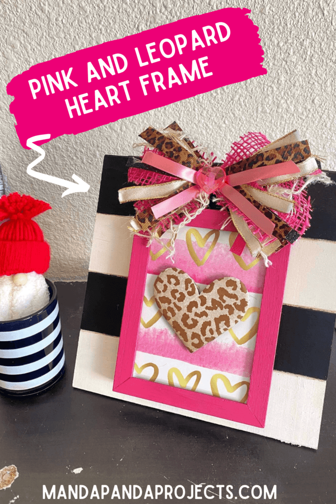 Pink and Leopard layered heart frame on a black and white striped background for easy Valentine's Day crafts and decor with a messy bow.
