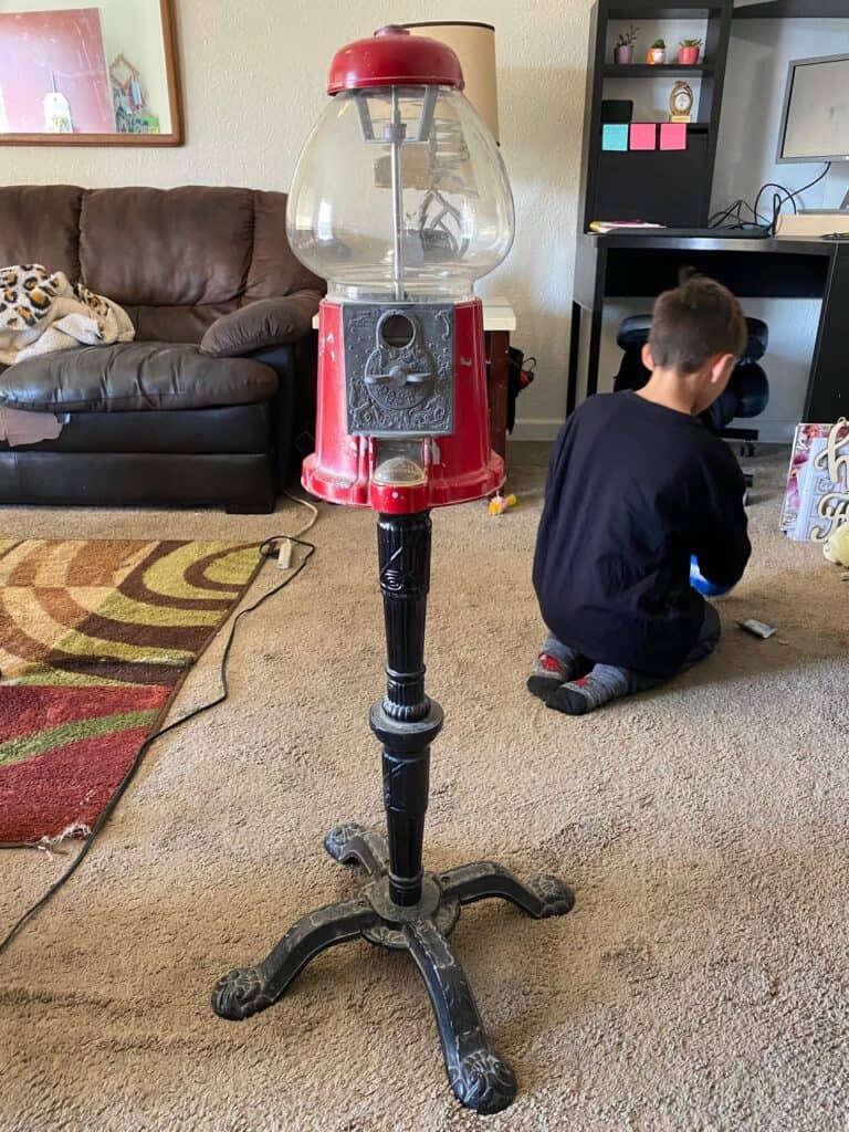 Before picture of a red vintage gumball machine from an Antique thrift store.