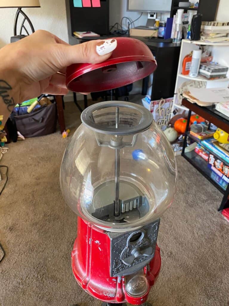 First step of making over the vintage gumball machine is to take the red top off and separate the glass from the base.