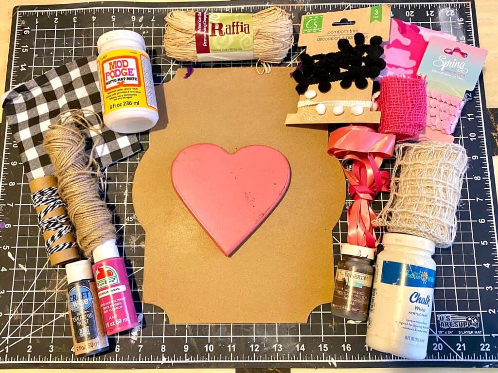 Supplies needed to make a pink buffalo check valentines heart for February 14th.