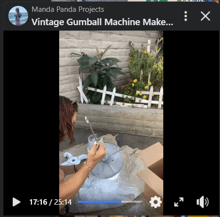 Amanda spray painting the gumball machine white ona Facebook Live thumbnail.