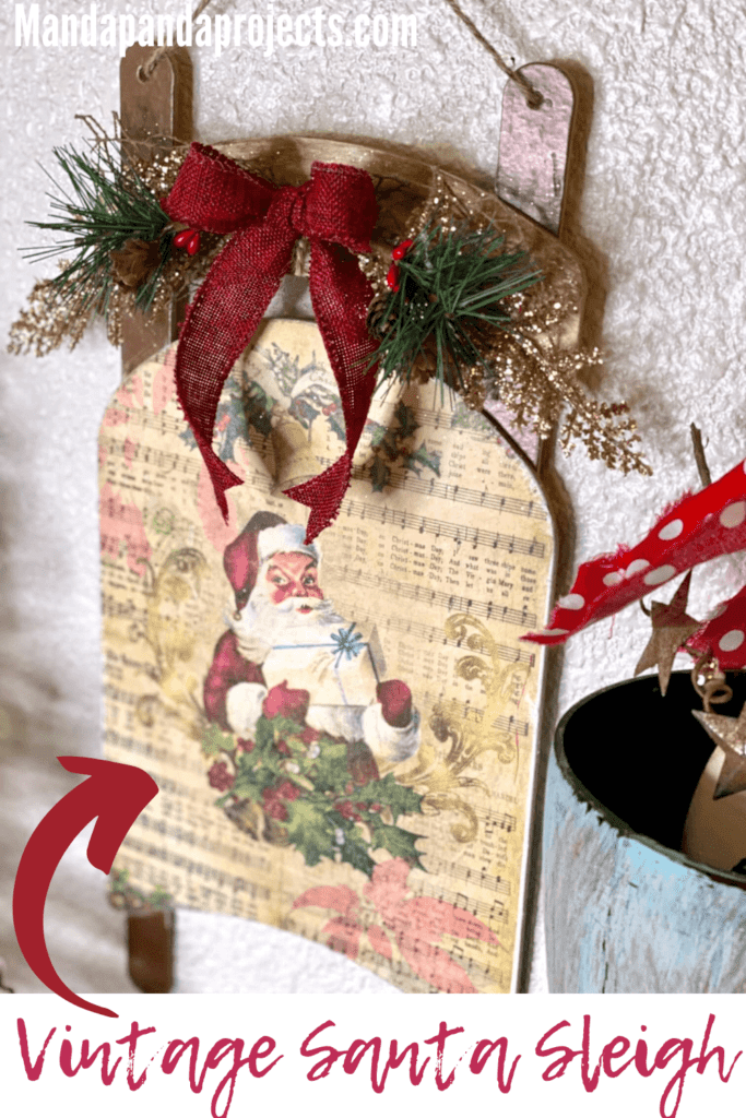 Dollar Tree Vintage Santa Sleigh with craft printable decoupaged onto wood and old music sheet background DIY Christmas Decor