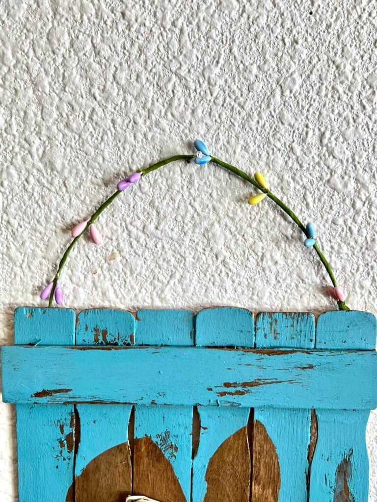 Easter pip berry garland as the hanger for the wood paint stick project.
