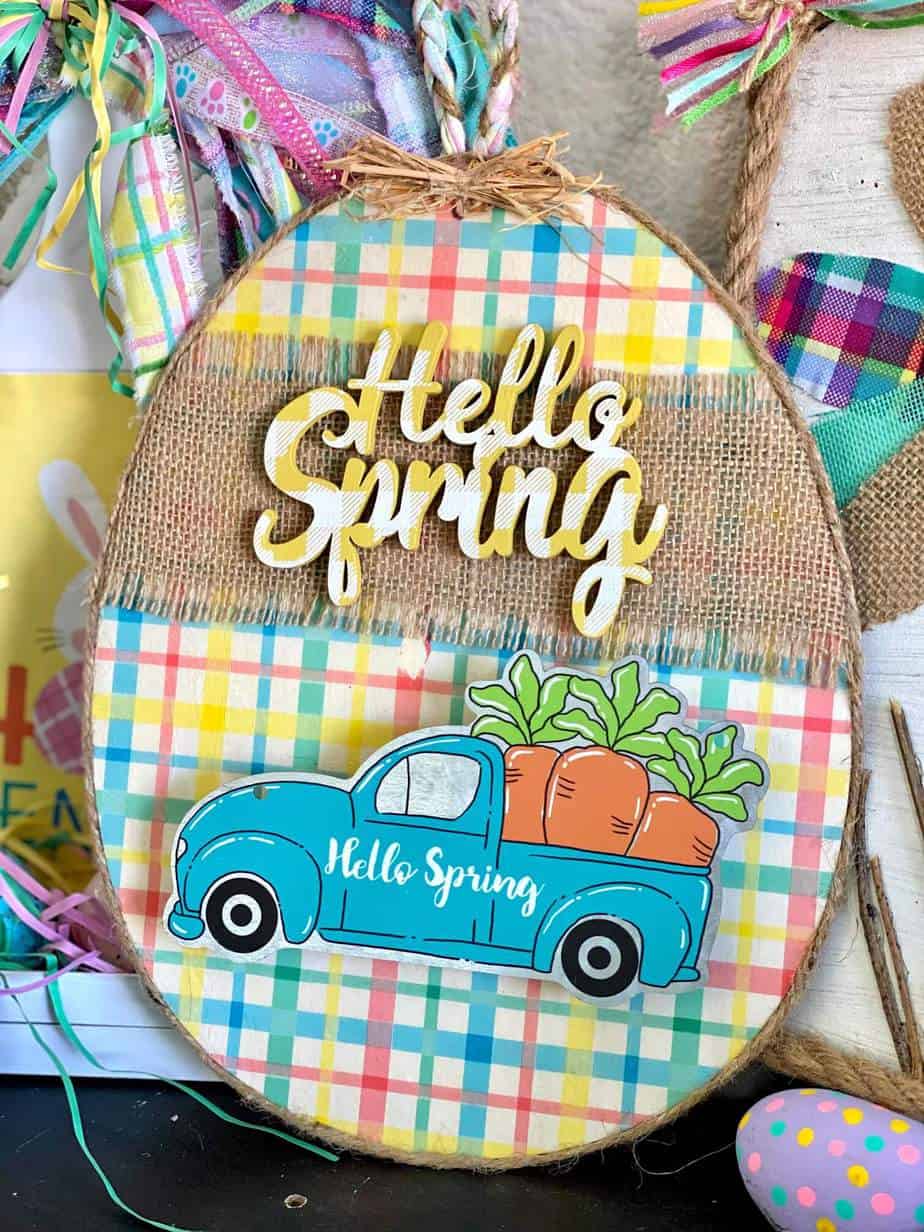 Dollar Tree Hello Spring Truck easter egg DIY with yellow plaid tissue paper, burlap, and carrots in the bed of the truck.
