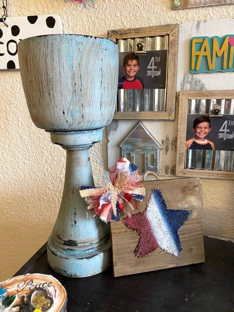 Thrift Store Chunky Candlestick flip. Painted and distressed it, and it's sitting on a bookcase next to a burlap star.