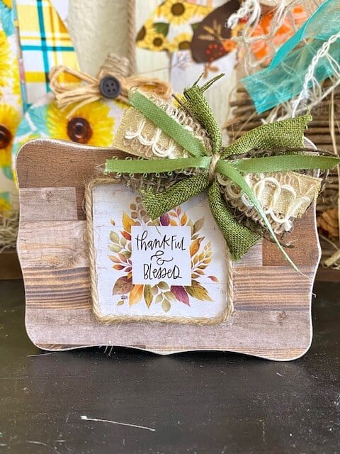 Dollar Tree Mini back of the calendar 'Thankful and Blessed" tiered tray decor block with a faux wood finish and mini bow.