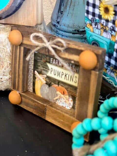 Close up of the mini jenga block frame with the farm fresh pumpkins calendar print inside and a twine bow at the top.