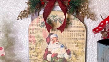 Dollar Tree Vintage Santa Sleigh with craft printable decoupaged onto wood and old music sheet background DIY Christmas Decor
