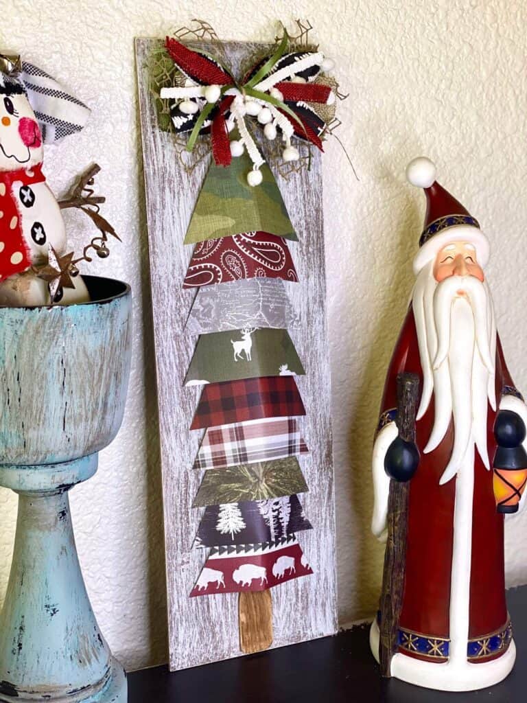 DIY Scrapbook paper Christmas tree next to a rustic santa and a foam dice snowman.