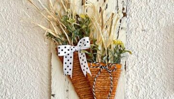 Spring cardboard carrot craft made with a twine wrapped carrot on a white chippy background and a wood bead hanger for DIY Easter decor